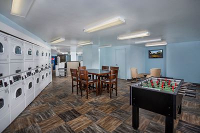 laundry facility at Colesville Towers Silver Spring apartments for rent with seating area and foosball table